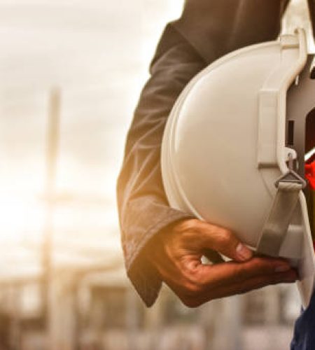 Technician holding white hat safety hard hat sunlight background